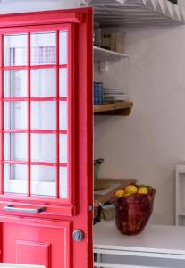 a red door in a kitchen with a basket of fruit at Little house town mykonos in Mikonos