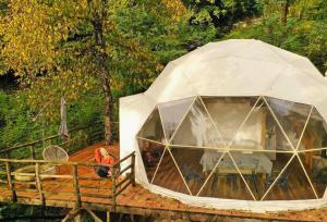 - une tente sur une terrasse en bois avec des personnes dans l'établissement Wine Space, à Ambrolaouri