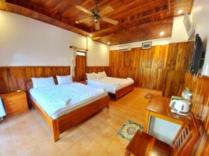 sypialnia z 2 łóżkami i wentylatorem sufitowym w obiekcie Viet Thanh Resort w Duong Dong