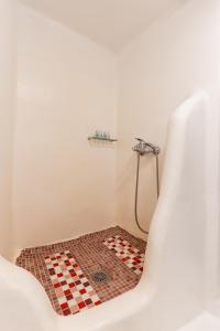 a bathroom with a bath tub with a checkered floor at Little house town mykonos in Mikonos