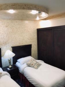 een slaapkamer met 2 bedden en een lamp op een tafel bij ZRIZIRA INN in Wadi Musa