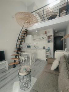 a living room with a spiral staircase and a kitchen at Lovely apartment Nadolnik in Poznań