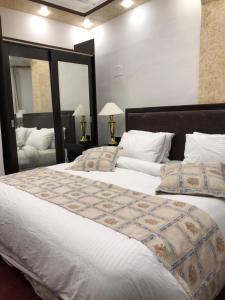 een slaapkamer met 2 bedden en een grote spiegel bij ZRIZIRA INN in Wadi Musa