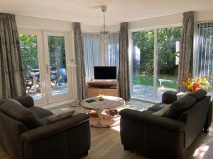 a living room with two couches and a television at Karekiet 42 in Oudemirdum