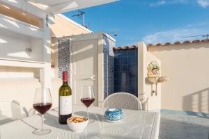 un tavolo con una bottiglia di vino e due bicchieri di Reef and Dream a San Vito lo Capo