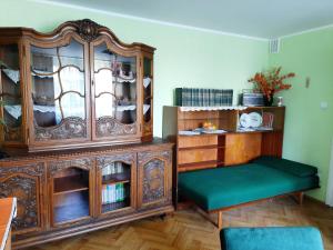 - un salon avec une grande armoire en bois et un banc vert dans l'établissement Stylowe PRLove - Dom Dyrektora, à Rogowo