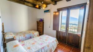 a bedroom with a bed and a sliding glass door at Cortijo Vaquero Rural Loja by Ruralidays in Loja