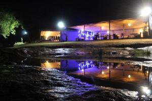 un riflesso di un edificio in una pozzanghera di notte di Lions Rock Rapids - Luxury Tented Camp a Hazyview