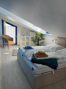 a bedroom with a large bed with a sloped ceiling at Bodden-Adler in Fuhlendorf