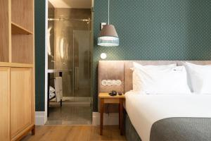 a bedroom with a bed and a green wall at Boemio FLH Hotels in Lisbon