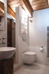 uma casa de banho com um WC branco e um lavatório. em Chalet Jessica em Saas-Fee