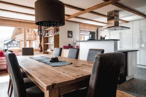 a kitchen and dining room with a wooden table and chairs at Chalet Jessica in Saas-Fee