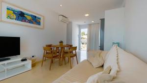 uma sala de estar com uma cama, uma televisão e uma mesa em Lago Resort Menorca - Villas & Bungalows del Lago em Cala'n Bosch