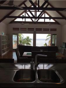 uma cozinha com um lavatório e vista para a praia em Island Breeze Fiji em Savusavu