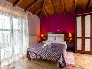 a bedroom with a large bed with purple walls at Erasmion in Áno Dholianá