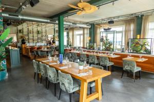 comedor con mesas y sillas de madera en EuroParcs Poort van Amsterdam, en Uitdam