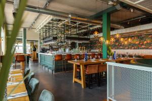 a restaurant with tables and chairs and a bar at EuroParcs Poort van Amsterdam in Uitdam