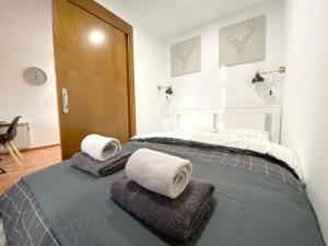 a bedroom with a bed with towels on it at Snow&Fun - Sierra Nevada - Monte Oiz in Sierra Nevada