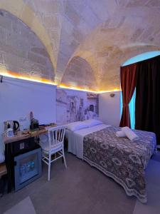 a bedroom with a bed and a desk with a computer at The Bridge Suites in Gravina in Puglia +80 photos