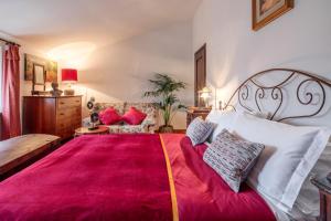 a bedroom with a large bed with a red blanket at Borgodoro - Natural Luxury Bio Farm in Magliano Sabina