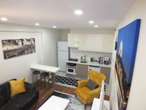 sala de estar con sofá, mesa y cocina en Central Cozy Flat with Terrace & Sea View, en Estambul