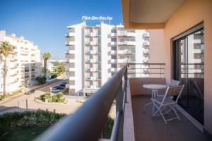 a balcony with a table and chairs and a building at A17 - Heaven Sun Praia da Rocha 1 Bed Apartment in Portimão