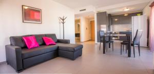 a living room with a couch and a table with pink pillows at A17 - Heaven Sun Praia da Rocha 1 Bed Apartment in Portimão