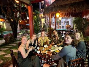 a group of women sitting around a table eating food at Phong Nha Tuan Garden House in Phong Nha