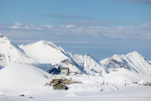 a building in the snow with mountains in the background at Berghotel Engstligenalp Adelboden in Adelboden