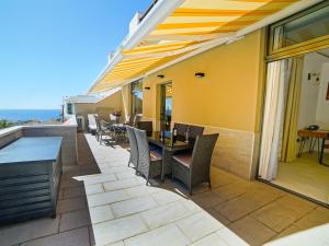 a patio with tables and chairs on a balcony at Deluxe Suite 70qm. Toller Blick, super Ausstattung in Calera