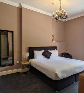 a bedroom with a bed with a mirror and a chandelier at Blue Keys Hotel Southampton in Southampton