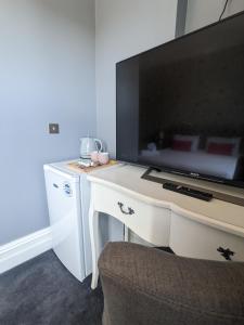 uma secretária branca com uma televisão por cima em Blue Keys Hotel Southampton em Southampton