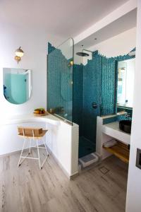 a bathroom with a shower with a chair and a table at Caldera's Majesty in Imerovigli