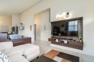 a living room with a large flat screen tv at Brand New - Bungalow - Ocean View - Discovery Bay in Discovery Bay