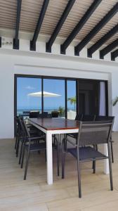 a dining room with a table and chairs and the ocean at Sunset Beachfront Penthouse Cap Ouest Flic en Flac in Flic-en-Flac