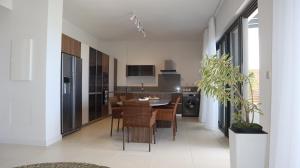 a kitchen and dining room with a table and chairs at Sunset Beachfront Penthouse Cap Ouest Flic en Flac in Flic-en-Flac