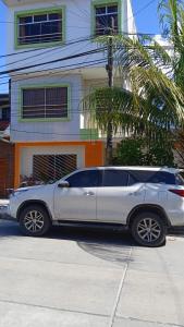 un coche plateado estacionado frente a una casa en 100 RV Apartments Iquitos-Apartamento primer piso con vista a piscina, en Iquitos
