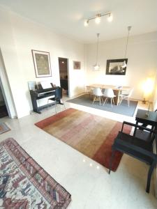 a living room with a piano and a table at SAILORS LUXURY APPARTMENT 130m2 in Athens