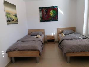 1 dormitorio con 2 camas individuales y una pintura en la pared en BLATNIKOV HRAM en Dvor