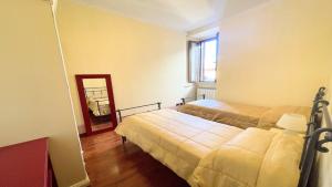 a small room with two beds and a mirror at huge town house in Spoleto storico - car unnecessary - wifi - sleeps 10 in Spoleto