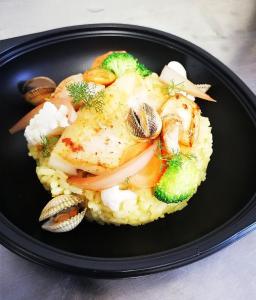 un plato de comida con pollo y verduras en arroz en Logis Hôtel et Restaurant La Bombardière, en Cuq-Toulza
