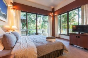 a bedroom with a large bed with a flat screen tv at ปานเทล เขาใหญ่ Parntel KhaoYai in Khao Yai