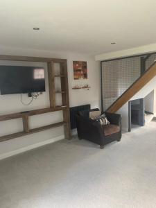 a living room with a couch and a flat screen tv at Upstairs river apartment in Gloucester