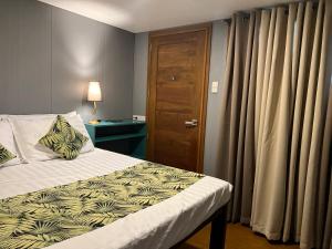 a bedroom with a bed and a wooden door at Happy Camper Hostel in Coron