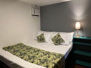 a small bedroom with a bed with a white sheets and pillows at Happy Camper Hostel in Coron
