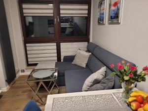 un soggiorno con un divano blu e un tavolo di Apartament Chmielna - Waterlane Island a Danzica