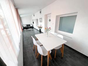a white dining room with a white table and chairs at Williams Apartments Prague in Prague