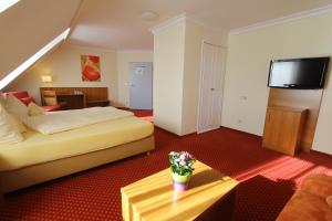 une chambre d'hôtel avec un lit et une table dans l'établissement Abasto Hotel Eichenau, à Eichenau