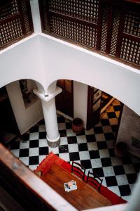 a room with a table and chairs on a checkered floor at The Riad Hostel Tangier in Tangier