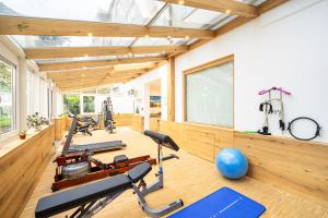 einen Fitnessraum mit Trainingsgeräten und einem großen Fenster in der Unterkunft Park Hotel Laim in München